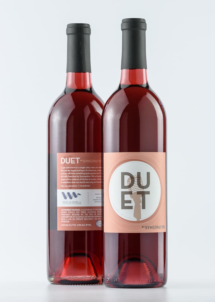 Duet rosé wine bottles on white background.